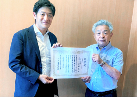 表彰状を持つ様子